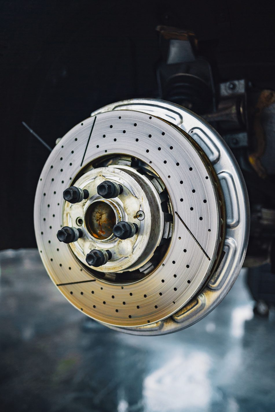 Licensed stock photograph: a drilled and slotted brake rotor mounted on a hub with the wheel removed.